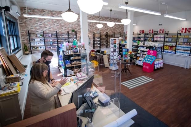 Richard (with mask) behind the counter with another employee a few days before Boyd's Pharmacy opened on Agricola Street in Halifax.