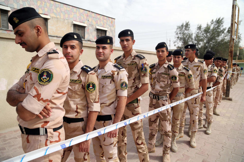 Security forces and army personnel queue to vote outside a polling center in Basra, Iraq's second-largest city, 340 miles (550 kilometers) southeast of Baghdad, Iraq, Monday, April 28, 2014. Amid tight security, some one million Iraqi army and police personnel have started voting for the nation's new parliament. (AP Photo/ Nabil al-Jurani))