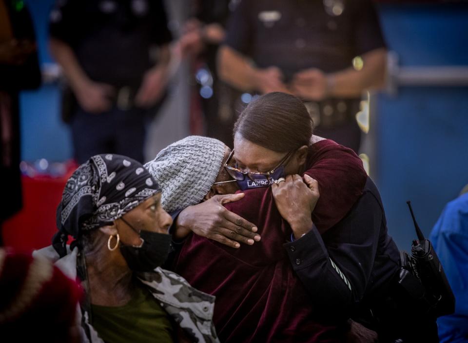 Masked people hug during a party.