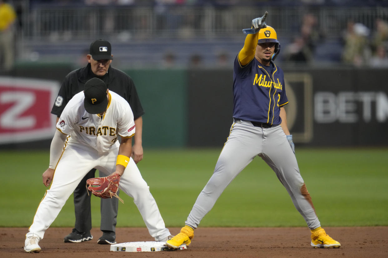 Milwaukee Brewers' Willy Adames, right, celebrates after stealing second base ahead of the tag attempted by Pittsburgh Pirates second baseman Nick Yorke, left, with umpire Manny Gonzales, left rear, making the call during the second inning of a baseball game in Pittsburgh, Tuesday, Sept. 24, 2024. (AP Photo/Gene J. Puskar)