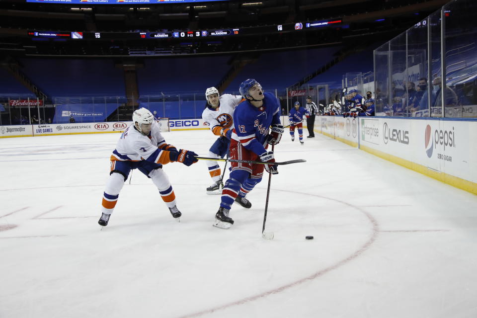 New York Islanders' Jordan Eberle, left, hits New York Rangers' Julien Gauthier during the second period of an NHL hockey game Thursday, Jan. 14, 2021, in New York. (Bruce Bennett/Pool Photo via AP)