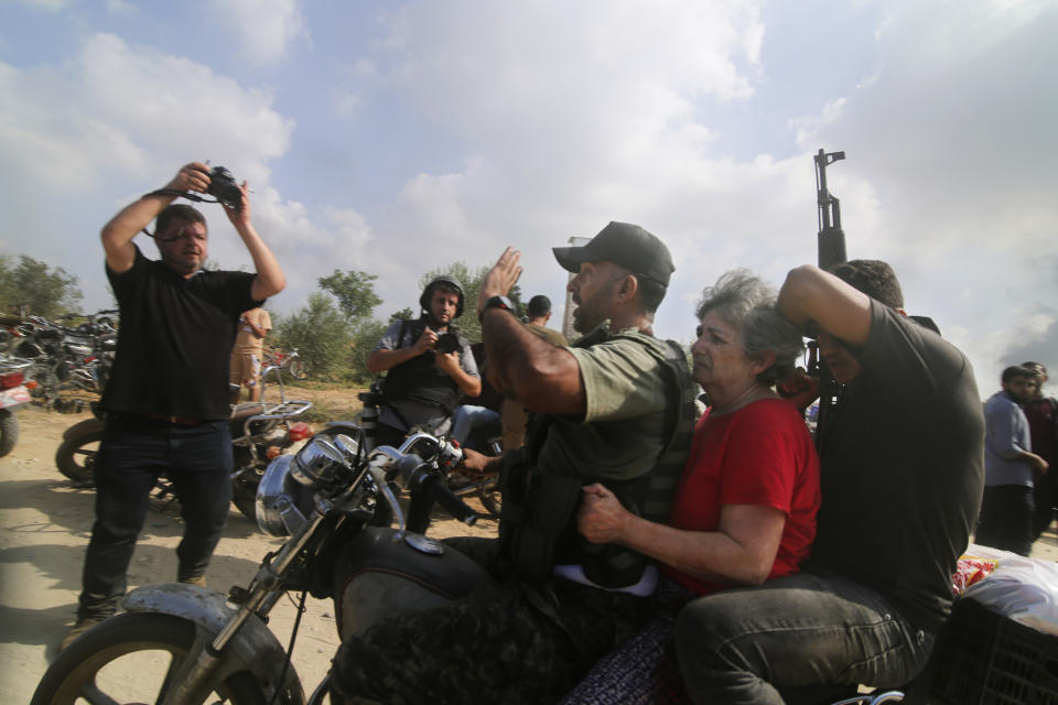 FILE - Palestinians transport a captured Israeli civilian, Adina Moshe, from her home in Kibbutz Nir Oz to the Gaza Strip on Oct. 7, 2023. An Associated Press review of hundreds of messages shared among Nir Oz residents, security camera footage and Hamas instruction manuals show the group planned ahead of time to target civilians, a change in tactic that heavily impacted how the war in Gaza played out. (AP Photo, File)