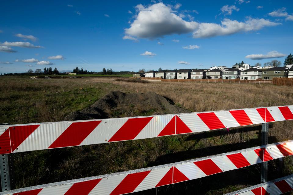 Homes are seen on Thursday, Feb. 22, 2024, in the southwest Portland, Ore., suburb of Beaverton. The so-called urban growth boundary, established by a 1973 law that placed boundaries around cities to prevent urban sprawl and preserve nature and farmland, is seen in the background along SW Tile Flat Road. (AP Photo/Jenny Kane)