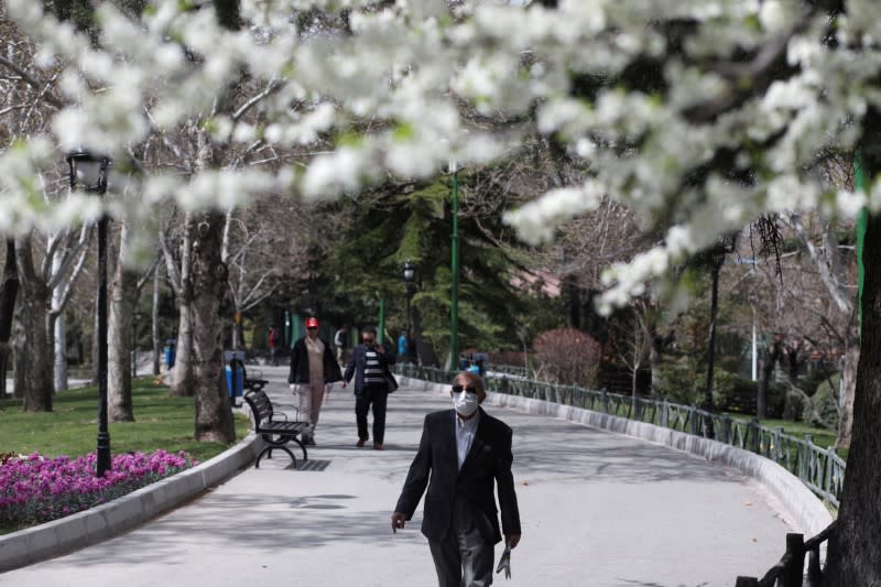 FILE PHOTO: A man wears a protective face mask, amid fear of coronavirus disease (COVID-19), as he walks at Mellat park, ahead of the Iranian New Year Nowruz, March 20, in Tehran