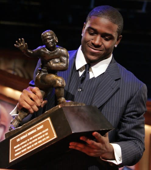 FILE - This Dec. 10, 2005, file photo shows Southern California football player Reggie Bush picking up the Heisman Trophy.