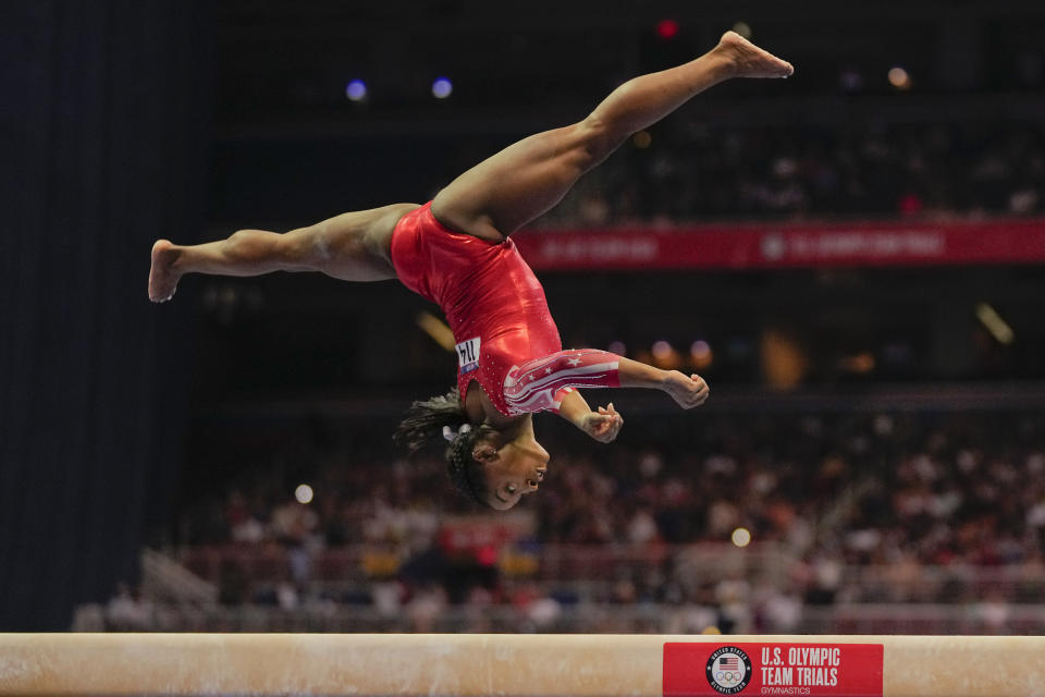 Simone Biles compite en la viga de equilibrio en el campeonato clasificatoria de gimnasia de Estados Unidos, en San Luis, el domingo 27 de junio de 2021. (AP Foto/Jeff Roberson)