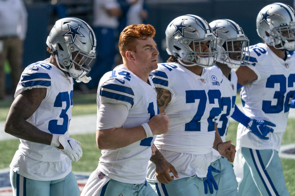 FILE - In this Sunday, Sept. 27, 2020 file photo, Dallas Cowboys, from left, Deante Burton, Andy Dalton, Trysten Hill, Donovan Wilson and Saivion Smith jog on to the field before an NFL football game against the Seattle Seahawks in Seattle. The first game between 1-5 Washington and the 2-4 Dallas Cowboys since the name change is also the longtime NFC East rivals’ first meeting with this bad a combined winning percentage since 2001. That was a 9-7 game kicker Tim Seder won with a 26-yard field goal as time expired after a collision with a horse on the field during warmups. (AP Photo/Stephen Brashear, File)