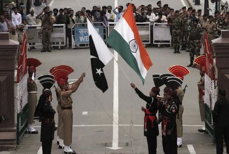 Pakistani rangers (wearing black uniforms) and Indian Border Security Force (BSF) officers lower their national flags during a daily parade at the Pakistan-India joint check-post at Wagah border, near Lahore November 3, 2014. REUTERS/Mohsin Raza