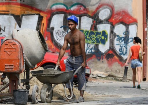 A construction worker works pushes a wheelbarrow in Bucharest on August 10. The recovery in Romania's economy after two years of severe recession is now coming under threat, analysts warn, victim to the months-long political crisis that has engulfed the EU country