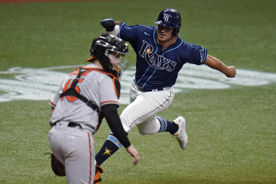 Tampa Bay Rays' Hunter Renfroe scores around Baltimore Orioles catcher Chance Sisco (15) on a sacrifice fly by Ji-Man Choi during the sixth inning of a baseball game Tuesday, Aug. 25, 2020, in St. Petersburg, Fla. (AP Photo/Chris O'Meara)