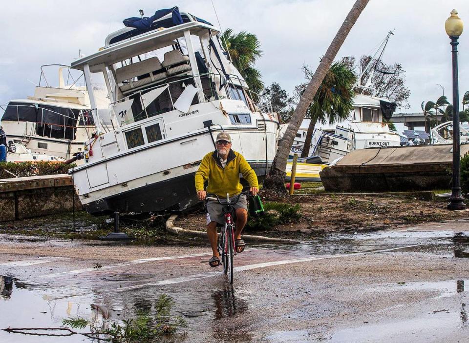 Un ciclista pasa junto a grandes embarcaciones desplazadas a tierra en Legacy Harbour Marina el jueves 29 de septiembre de 2022, el día después de que el huracán Ian golpeara Fort Myers Beach como tormenta de categoría 4.