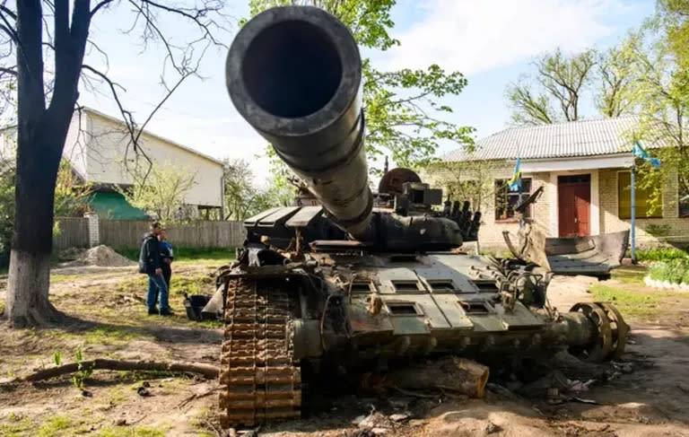 Habitantes locales junto a un tanque ruso destruido en Sloboda, en la ciudad de Chernígov, en el norte de Ucrania en mayo.