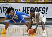 Colorado guard McKinley Wright IV, right, recovers the ball as UCLA guard Tyger Campbell defends in the first half of an NCAA college basketball game Saturday, Feb. 27, 2021, in Boulder, Colo. (AP Photo/David Zalubowski)