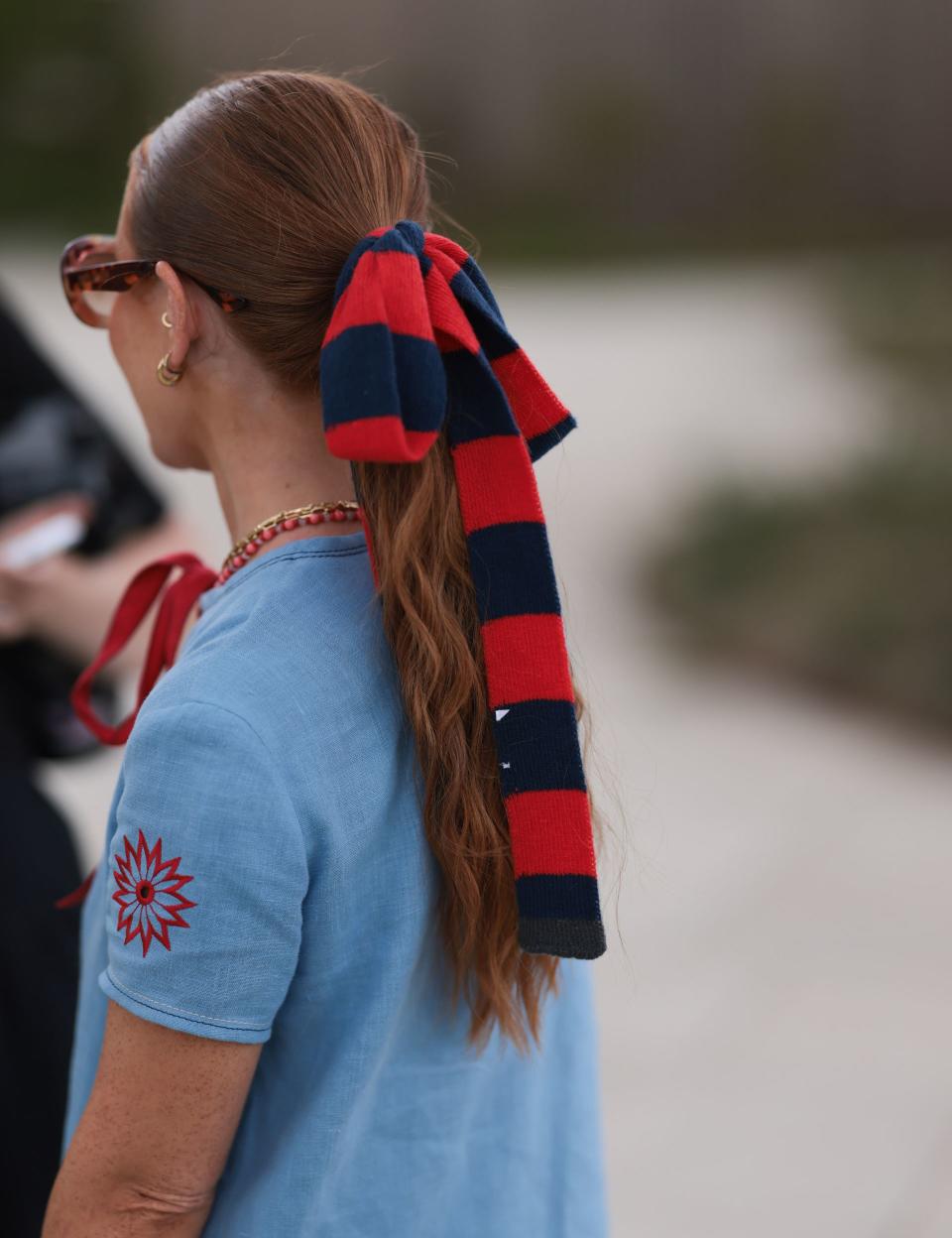 La queue de cheval nouée d'un tissu bleu et rouge