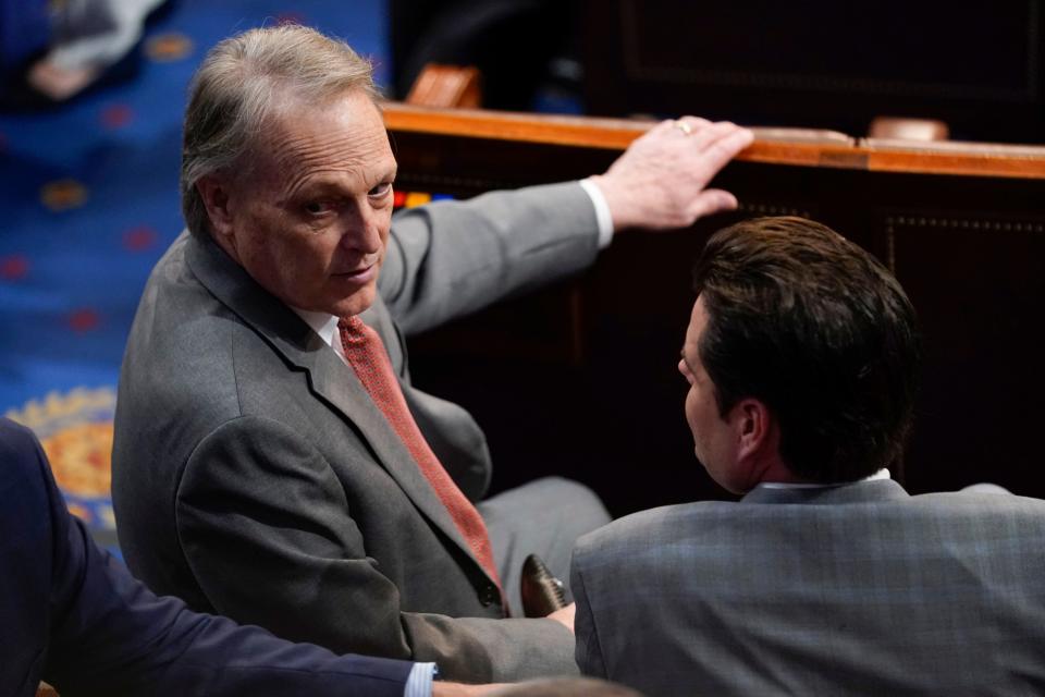 Rep. Andy Biggs, R-Ariz., turns as he speaks with Rep. Matt Gaetz, R-Fla., ahead of the 13th round of voting for speaker in the House chamber as the House meets for the fourth day to elect a speaker and convene the 118th Congress in Washington, Friday, Jan. 6, 2023.