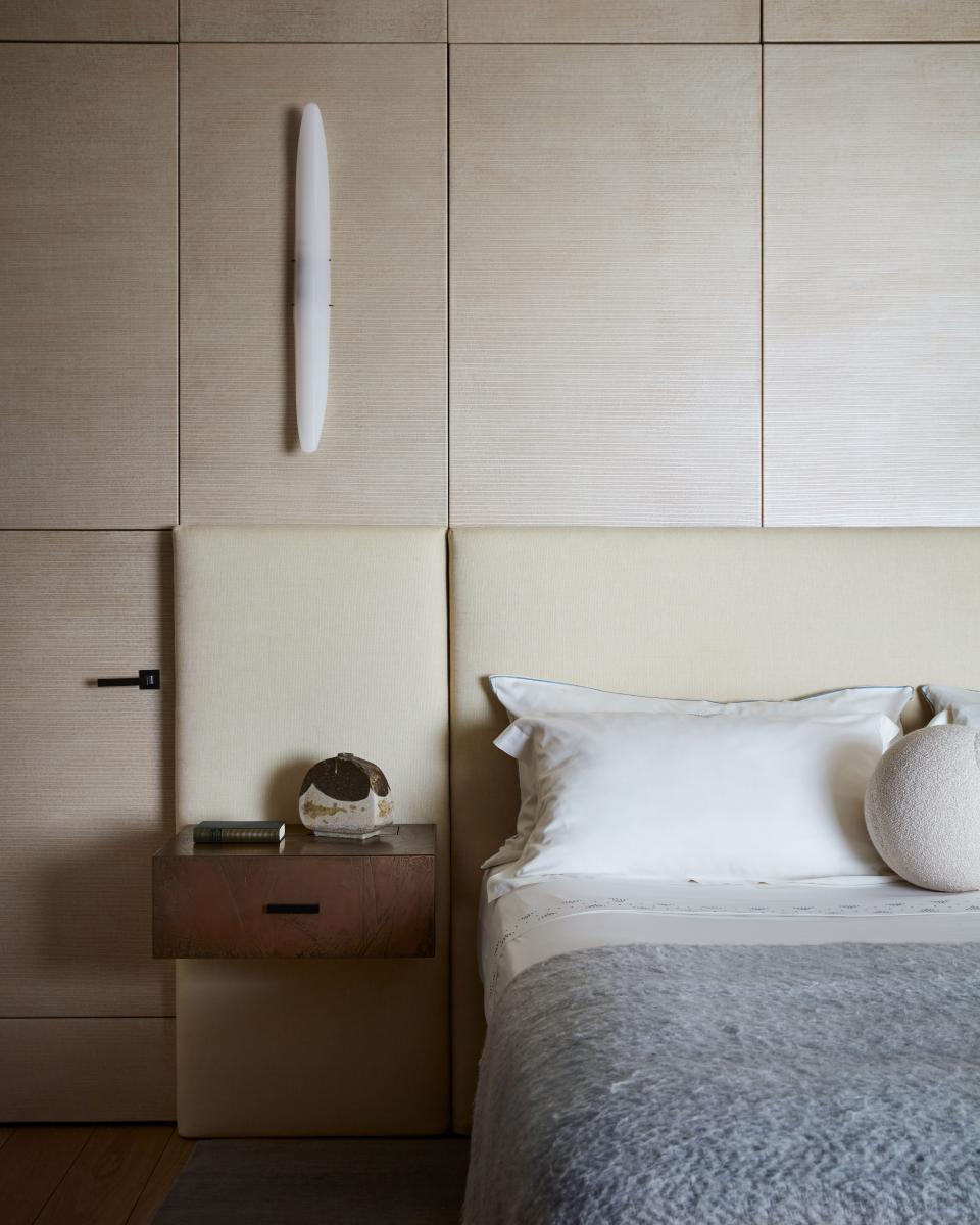 Handpainted leather panels on the walls add textural richness to the main bedroom. The small table lamps are by Paavo Tynell and the wall sconces are by Joseph-André Motte. Yovanovitch designed the bronze bedside table.