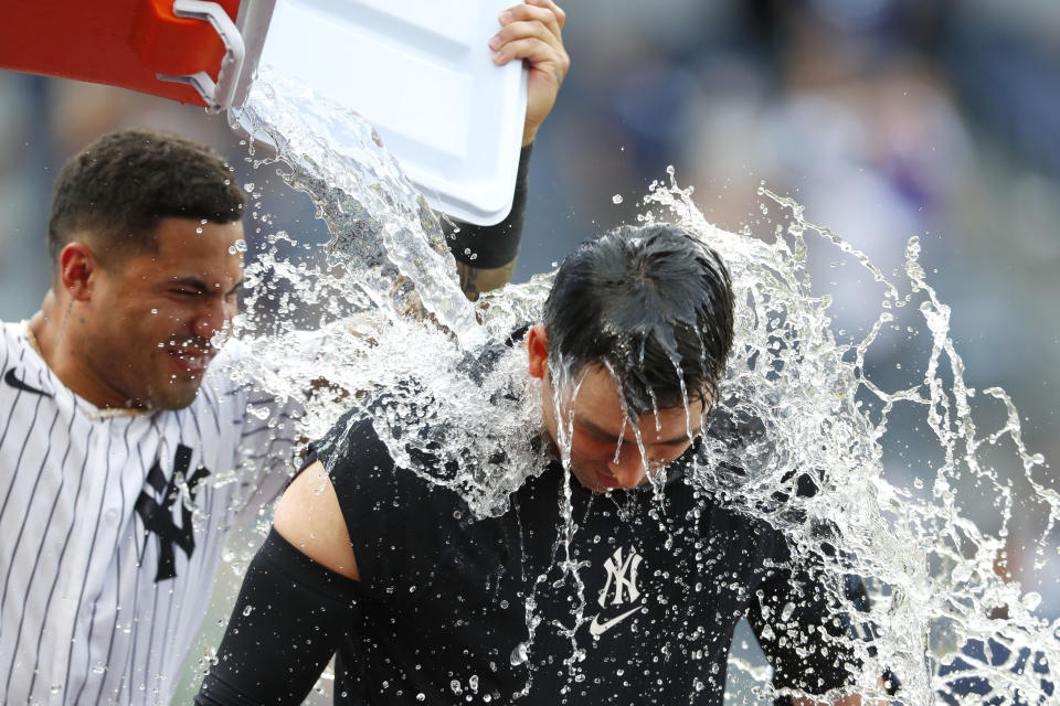 New York Yankees' Gleyber Torres, left, douses Kyle Higashioka after Higashioka's walkoff double against the Milwaukee Brewers during the 13th inning of a baseball game, Sunday, Sept. 10, 2023, in New York. (AP Photo/Noah K. Murray)