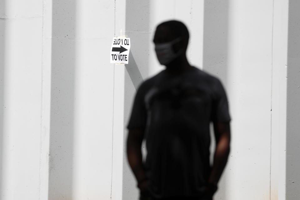 A man waits to vote at Central Park, Tuesday, June 9, 2020, in Atlanta. Voters reported wait times of three hours. (AP Photo/John Bazemore)