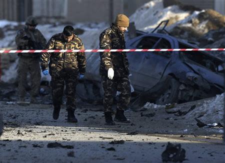 Afghan security personnel investigate at the site of a suicide bomb attack in Kabul