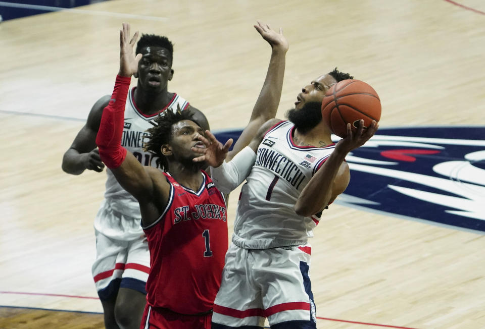 Jan 18, 2021; Storrs, Connecticut, USA; Connecticut Huskies guard R.J. Cole (right) shoots against St. John's Red Storm forward Josh Roberts (middle) in the first half at Harry A. Gampel Pavilion. Mandatory Credit: David Butler II-USA TODAY Sports