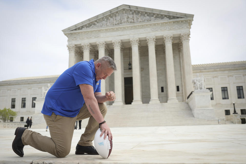 Former Bremerton High School assistant football coach Joe Kennedy takes a knee in front of the U.S. Supreme Court.