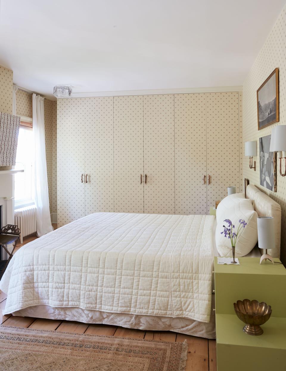 Colefax and Fowler wallpaper lines a bedroom where smith boldly covered a window with closets.