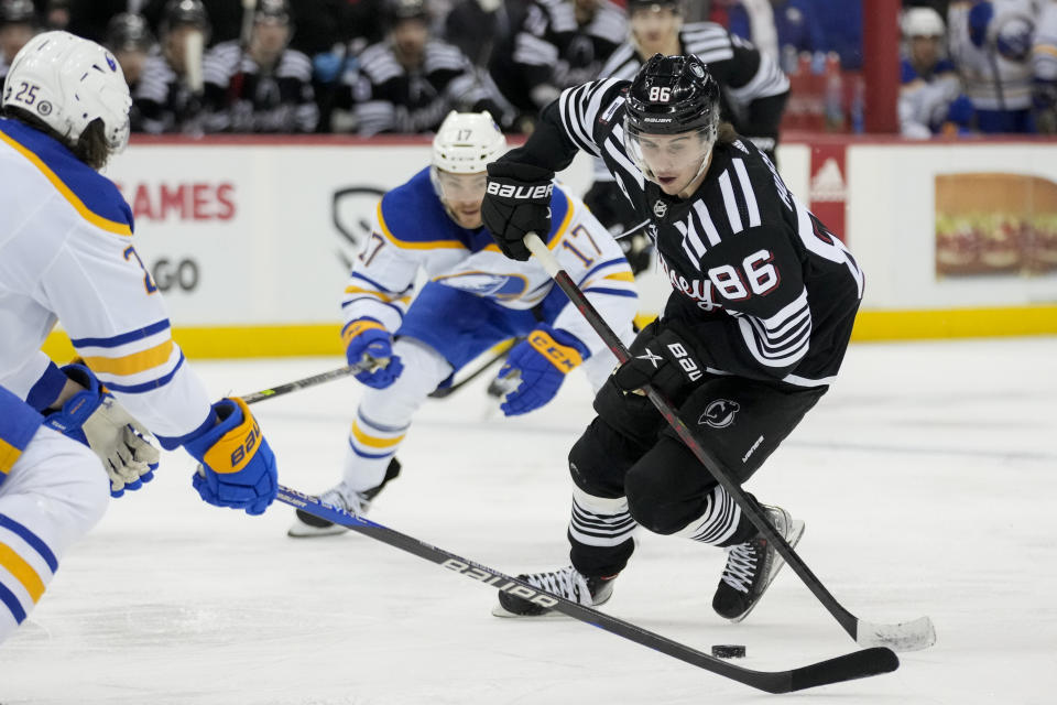 New Jersey Devils center Jack Hughes (86) skates the puck against Buffalo Sabres defenseman Owen Power (25) during the second period of an NHL hockey game, Tuesday, April 11, 2023, in Newark, N.J. (AP Photo/John Minchillo)