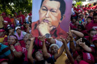 Supporters of Venezuela's President Hugo Chavez hold up an image of him during a campaign caravan from Barinas to Caracas, in Sabaneta, Venezuela, Monday, Oct. 1, 2012. Venezuela's presidential election is scheduled for Oct. 7. (AP Photo/Rodrigo Abd)