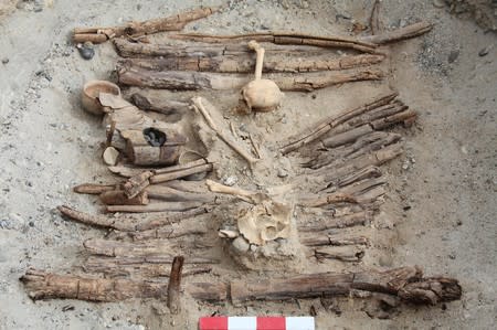 Wooden braziers and a skeleton found in the tomb M12 at an archaeological site in the Pamir Mountains in Xinjiang region