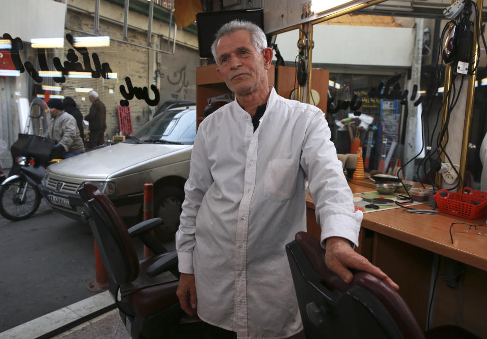 In this Jan. 22, 2019, photo, barber Bashir Nahavandi is interviewed by The Associated Press about Iran's 1979 Islamic Revolution at his shop in northern Tehran, Iran. Nahavandi was a taxi driver when the revolution took hold. He gave protesters free rides and took part in demonstrations against what he called the irreligious and immoral rule of Shah Mohammad Reza Pahlavi. He praised leaders for protecting Islam and enforcing the law that makes it mandatory for Iranian women to wear the hijab. (AP Photo/Vahid Salemi)