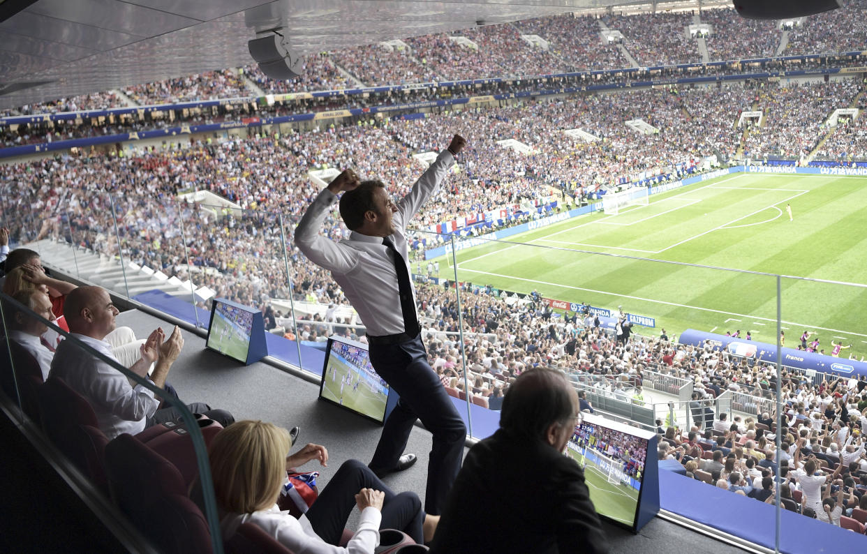 French President Emmanuel Macron is on his feet after France won the World Cup