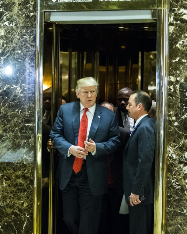 Donald Trump (left) exits the golden elevators to speak with media at Trump Tower on December 6, 2016 in New York