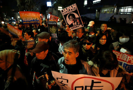 Protesters shout slogans and hold placards during a rally denouncing Japanese Prime Minister Shinzo Abe and Finance Minister Taro Aso over a suspected cover-up of a cronyism scandal in front of Abe's official residence in Tokyo, Japan March 14, 2018. REUTERS/Issei Kato