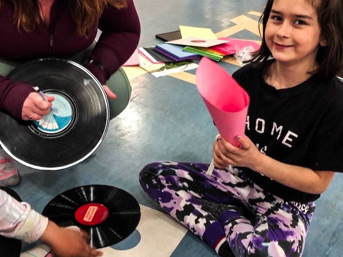 Olivia King of Tuktoyaktuk, N.W.T., makes an amplifier out on paper and sewing needle and spinning pencil to hear. (Karli Zschogner/CBC - image credit)