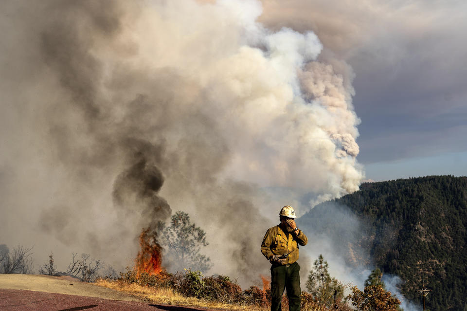 A firefighter rubs his face while battling the Mosquito Fire along Mosquito Ridge Rd. near the Foresthill community in Placer County, Calif., on Thursday, Sept. 8, 2022. (AP Photo/Noah Berger)