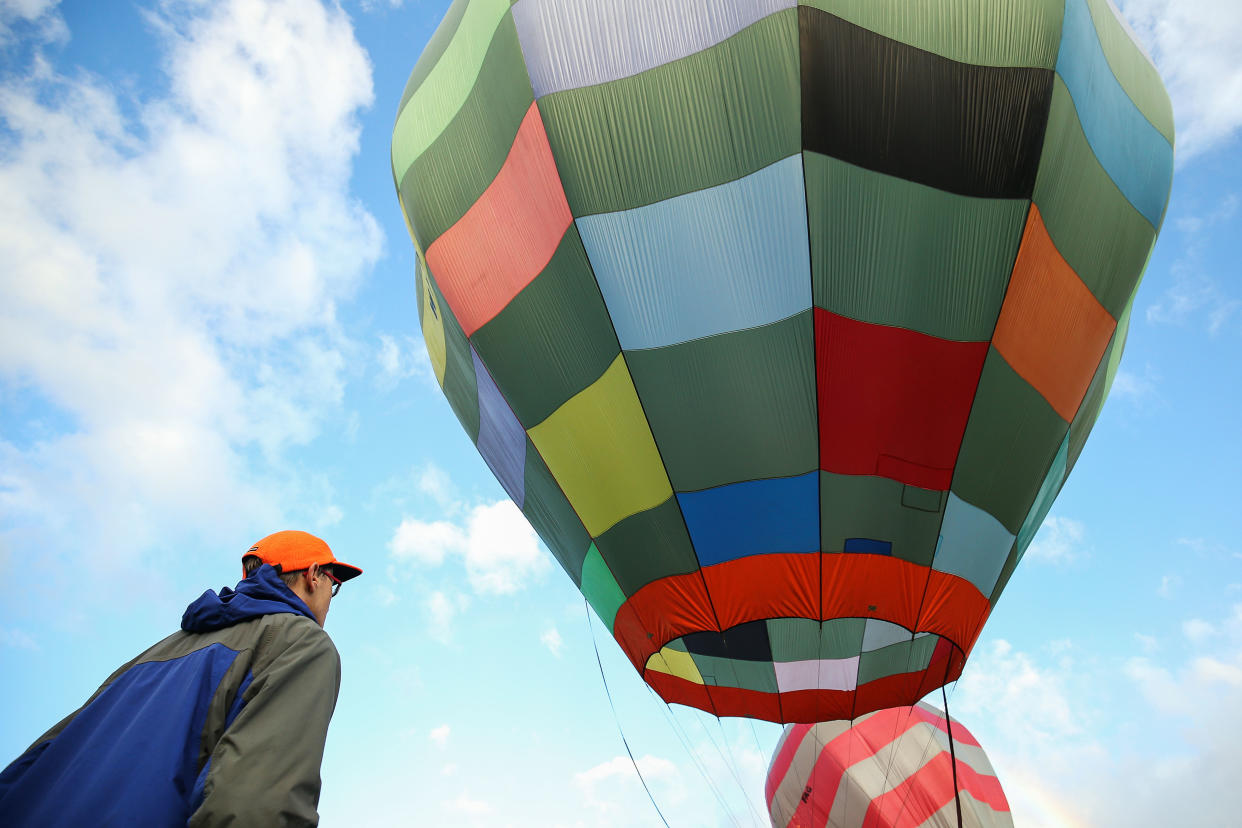 WELLINGTON, NEW ZEALAND - APRIL 15:  A spectator looks on as balloons inflate after poor weather kept pilots grounded during the Park to Paddock Challenge at the Wairarapa Balloon Festival on April 15, 2017 in Greytown, New Zealand. The Wairarapa Balloon Festival is an annual event and this year features two special international balloons - High Kitty from the United States, and Alien Rocket from Canada. The festival runs from 13 - 17 April, 2017.  (Photo by Hagen Hopkins/Getty Images)