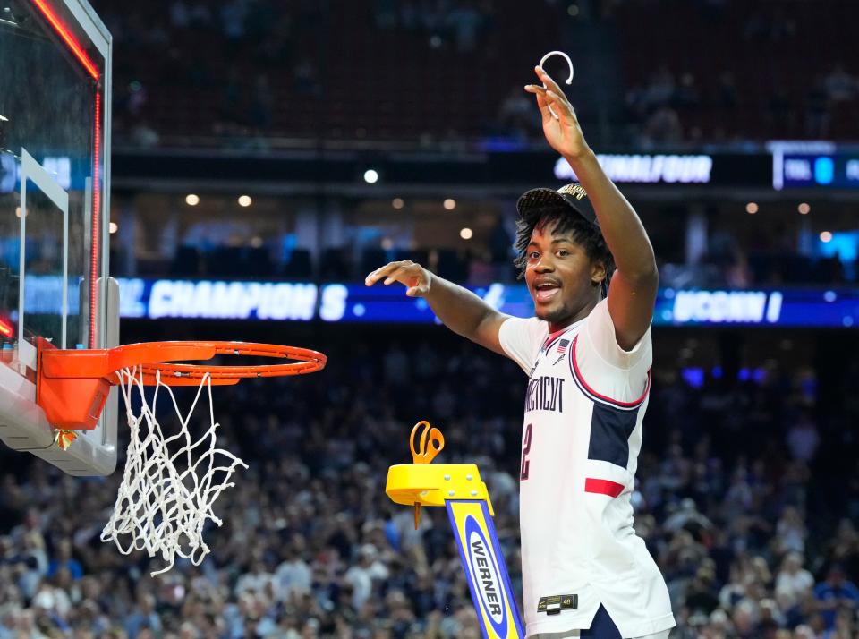Connecticut Huskies guard Tristen Newton (2) cuts down a piece of the net after defeating the San Diego State Aztecs in the national championship game of the 2023 NCAA Tournament.