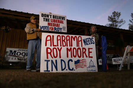 Supporters of Republican candidate for U.S. Senate Judge Roy Moore hold signs before a campaign rally in Midland City, Alabama, U.S., December 11, 2017. REUTERS/Jonathan Bachman