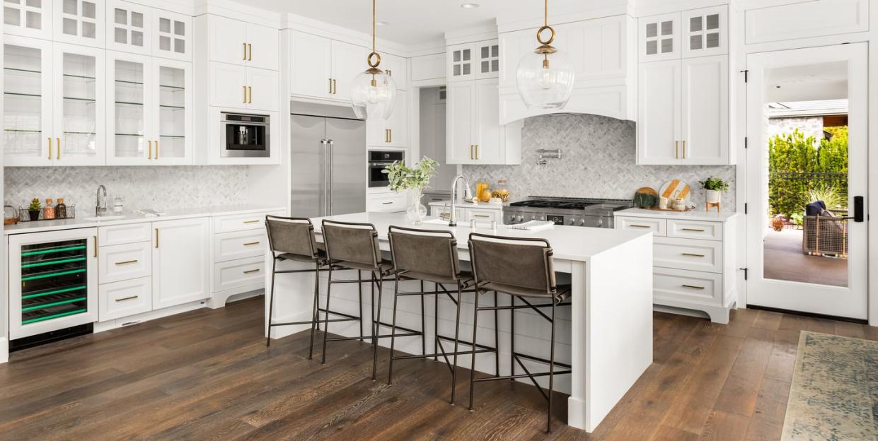 beautiful kitchen in new farmhouse style luxury home with island, pendant lights, and hardwood floors