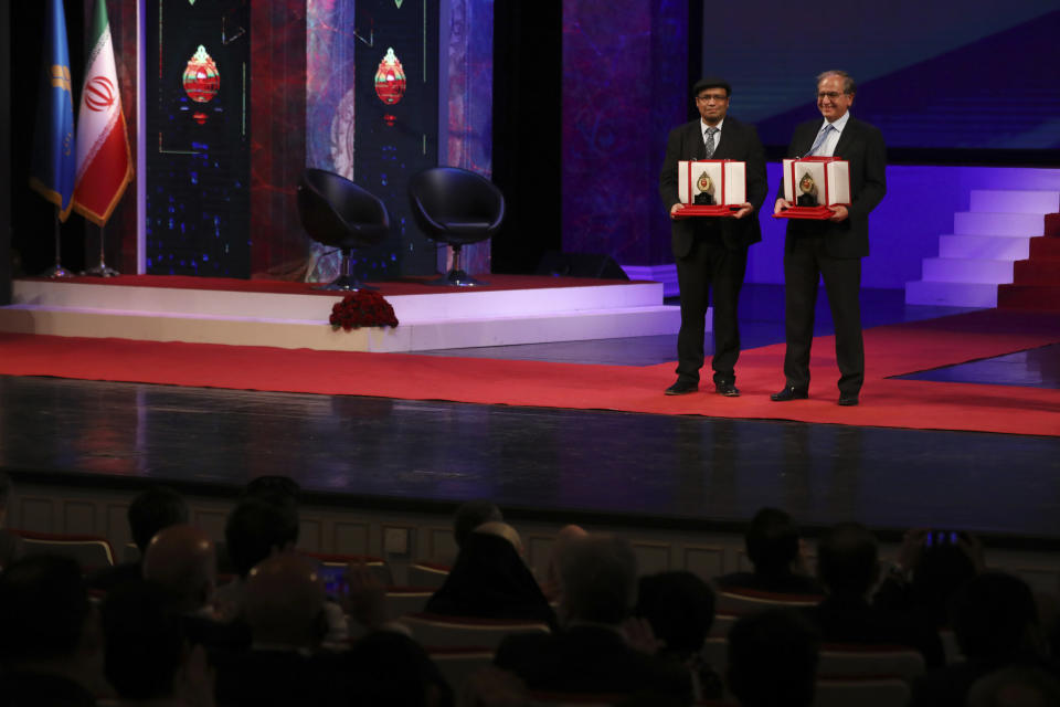 Iranian-American physicist Cumrun Vafa, right, a Harvard University physics professor, and quantum professor at Princeton University, Bangladesh-born Zahid Hasan, hold their awards during award giving ceremony of the biennial $500,000 Mustafa Prize, at Vahdat Hall in Tehran, Iran, Thursday, Oct. 21, 2021. Iran on Thursday awarded a prestigious prize in the study of science and technology to two physicists based in the United States. (AP Photo/Vahid Salemi)