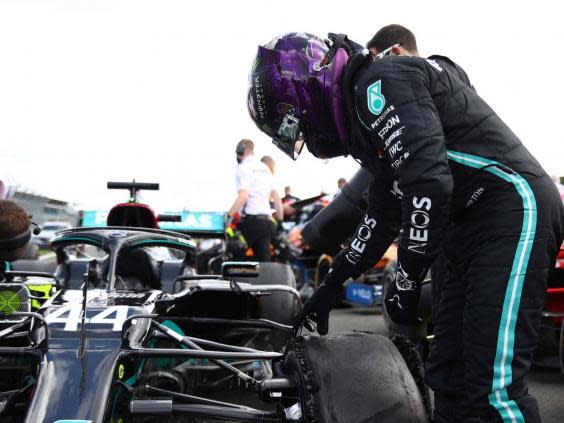 Lewis Hamilton inspects his damaged Mercedes after winning the British Grand Prix (AP)