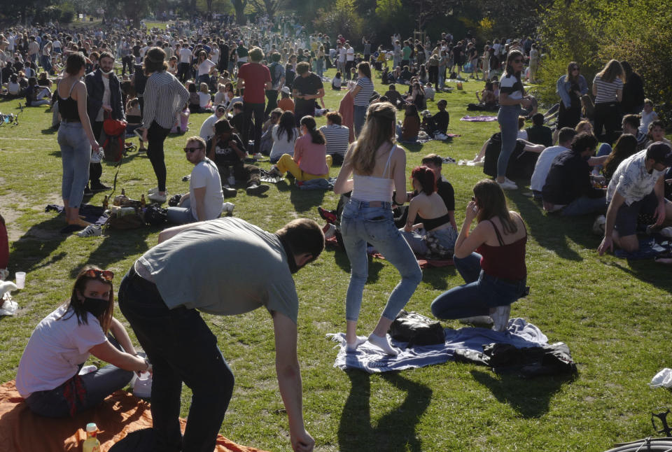 People sit on the grass in the Vauban park in Lille, northern France, Tuesday, March 30, 2021. The number of patients in intensive care in France on Monday surpassed the worst point of the country's last coronavirus surge in the autumn of 2020, another indicator of how a renewed crush of infections is bearing down on French hospitals. (AP Photo/Michel Spingler)