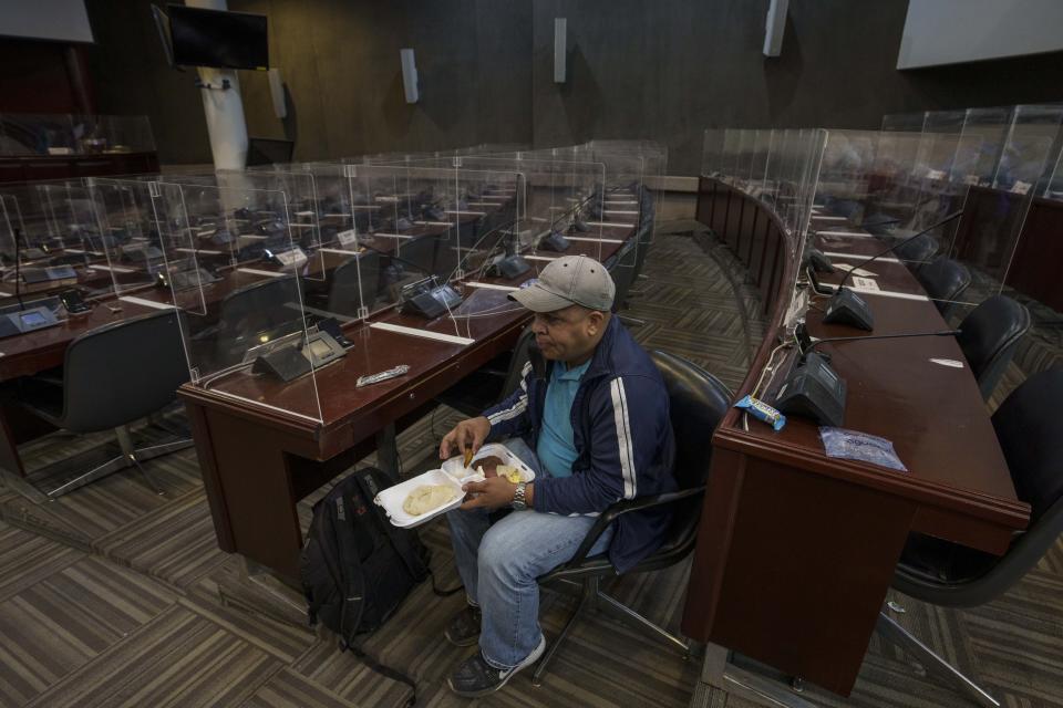 A supporter loyal to President-elect Xiomara Castro eats breakfast inside Congress as he and others occupy it in Tegucigalpa, Honduras, Wednesday, Jan. 26, 2022. The new president's supporters say they want to block opposition attempts to take over leadership of Congress, which could threaten her ability to govern after she is sworn in Jan. 27. (AP Photo/Moises Castillo)