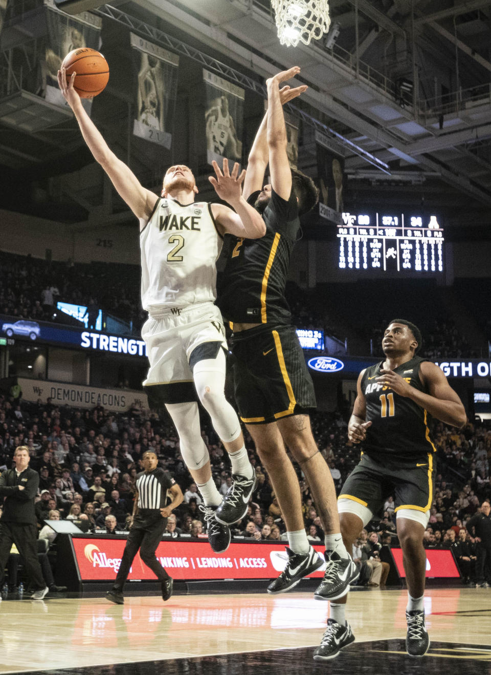 Wake Forest guard Cameron Hildreth (2) goes in for a layup with pressure from Appalachian State forward Christopher Mantis (2) in the first half of an NCAA college basketball game on Wednesday, Dec. 14, 2022, at Joel Coliseum in Winston-Salem, N.C. (Allison Lee Isley/The Winston-Salem Journal via AP)