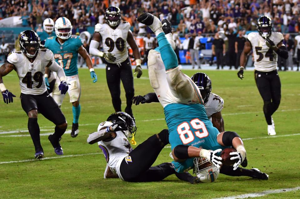 Miami Dolphins guard Robert Hunt (68) is upended while reaching for the end zone against the Baltimore Ravens.