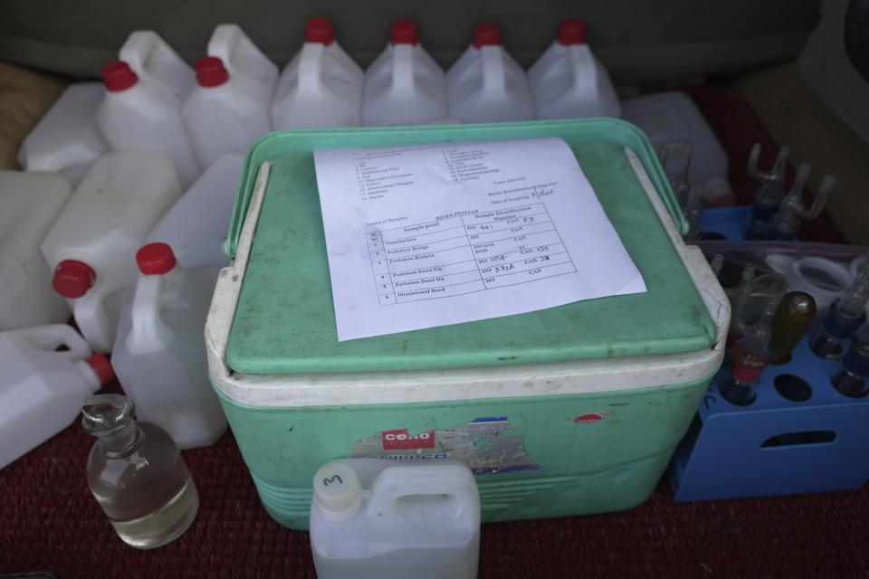 A document shows the samples of Periyar River water collected by Kerala Pollution Control Board trainees on the back of a truck in Eloor, Kerala state, India, Friday, March 3, 2023. Trainees take daily trips to collect samples from six different points along the river. (AP Photo)