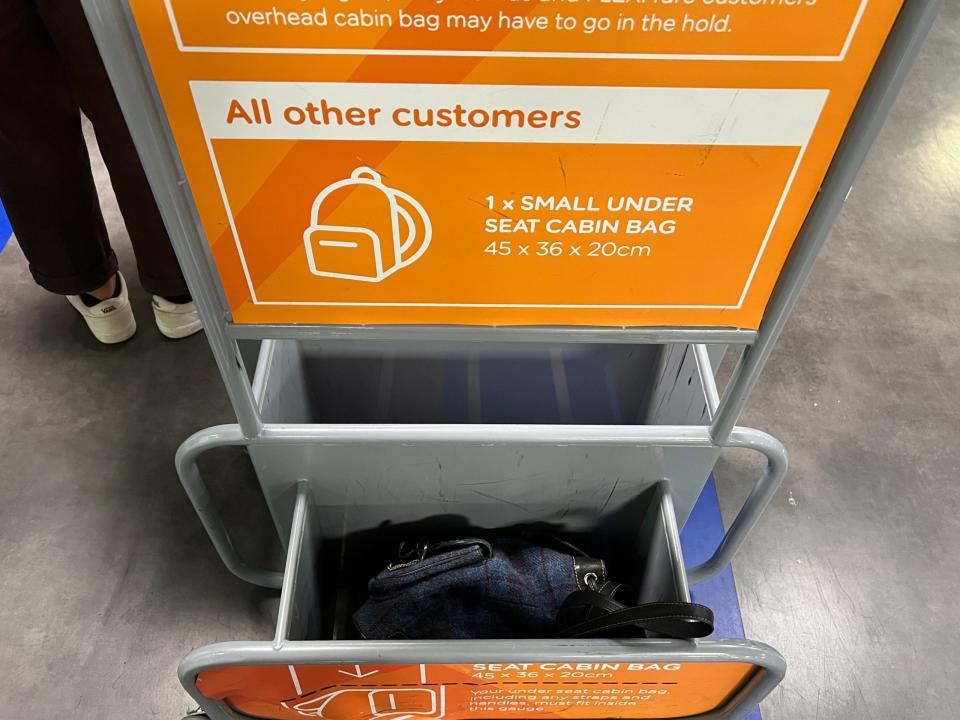 A rucksack placed inside an easyJet bag sizer at an airport.