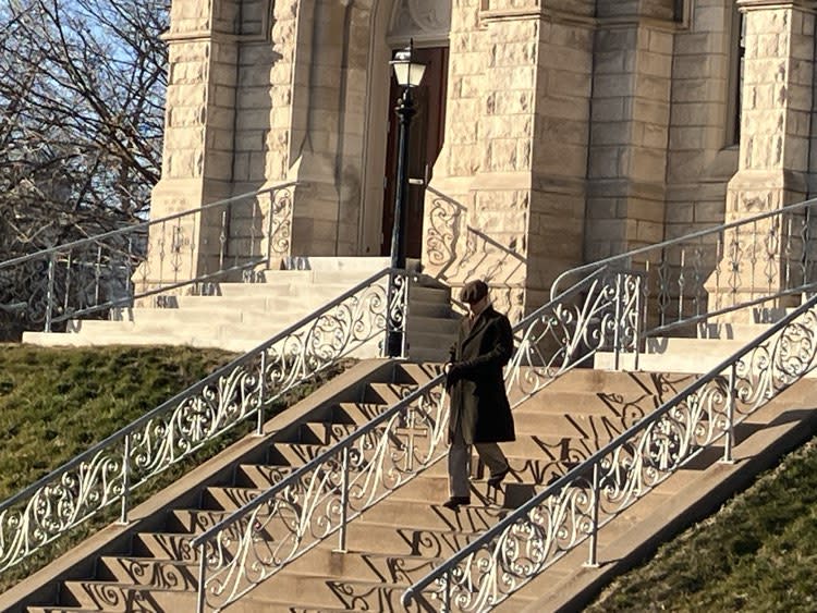 An Italian actor walks down the steps of Sacred Heart Cathedral, 422 E. 10th St., Davenport, during filming for “The Backyard.”