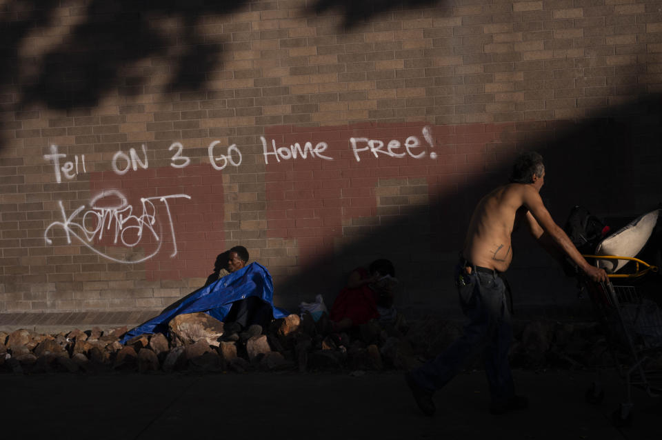 Two homeless men are seen outside a police station marked with graffiti in the Skid Row area of Los Angeles, Thursday, Sept. 14, 2023. The Skid Row neighborhood remains the epicenter of the crisis, where tents extend for blocks and unconscious people can be found splayed on sidewalks and slumped in doorways. Some streets have been transformed into parking lots for rusted, parked RVs. (AP Photo/Jae C. Hong)