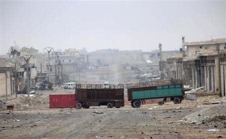 Damaged buildings and vehicles are pictured along a deserted street in the Aleppo town of Naqaren, after forces loyal to Syria's President Bashar al-Assad claimed to have regained control of the town, January 13, 2014. REUTERS/George Ourfalian